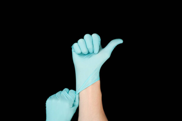 Hand in blue glove isolated on black with thumb up