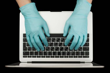 Eller dizüstü bilgisayarda yazan mavi koruyucu eldivenlerle. Üst Manzara. Coronavirus konsepti.