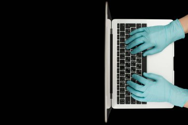 Eller dizüstü bilgisayarda yazan mavi koruyucu eldivenlerle. Üst Manzara. Coronavirus konsepti.