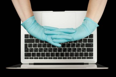 Eller dizüstü bilgisayarda yazan mavi koruyucu eldivenlerle. Üst Manzara. Coronavirus konsepti.