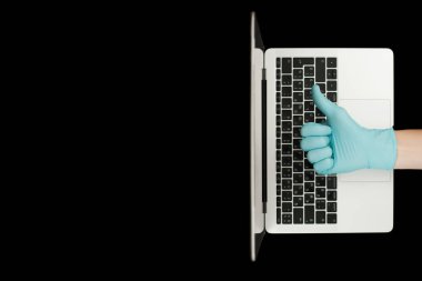 Mavi eldiven, baş parmaklarını gösteriyor. Taşınabilir laptop. Coronavirus koruması. 