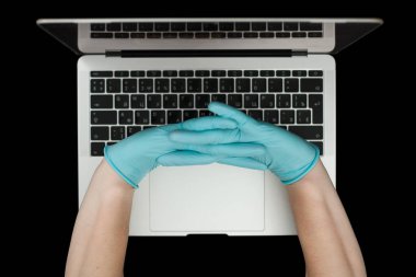 Eller dizüstü bilgisayarda yazan mavi koruyucu eldivenlerle. Üst Manzara. Coronavirus konsepti.