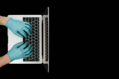 Eller dizüstü bilgisayarda yazan mavi koruyucu eldivenlerle. Üst Manzara. Coronavirus konsepti.