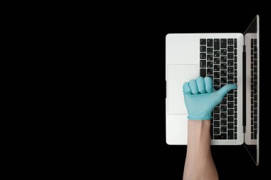 Mavi eldiven, baş parmaklarını gösteriyor. Taşınabilir laptop. Coronavirus koruması. 