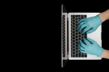 Eller dizüstü bilgisayarda yazan mavi koruyucu eldivenlerle. Üst Manzara. Coronavirus konsepti.