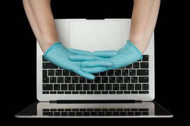 Eller dizüstü bilgisayarda yazan mavi koruyucu eldivenlerle. Üst Manzara. Coronavirus konsepti.