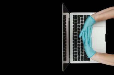 Eller dizüstü bilgisayarda yazan mavi koruyucu eldivenlerle. Üst Manzara. Coronavirus konsepti.