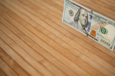 100 dolarlık banknot ve Benjamin Franklin 'in portresi. Ahşap arka planda 100 dolarlık banknotlar