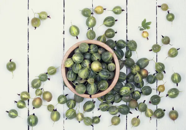 Green gooseberries in wooden bowl — Stock Photo, Image