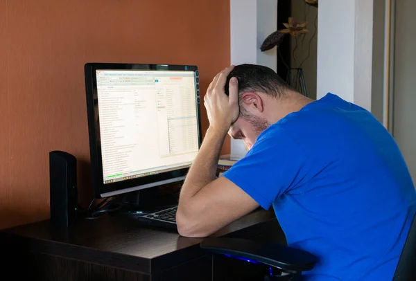 Tired busy man at the computer at home. The stress of boring work.