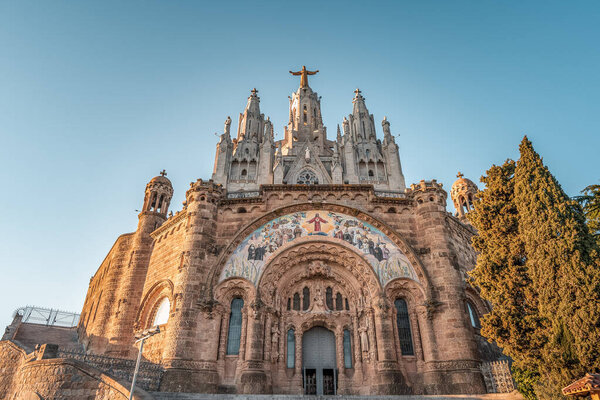 Facade of Temple of Expiatori del Sagrat Cor on top of Mont Tibidabo during sunset in Barcelona Spain in winter afternoon