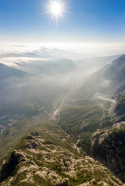 Авіаційний безпілотний вистріл автостради через гору Монсеррат біля Барселони з ранковим туманом — стокове фото