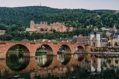 Yazın gün batımından sonra Neckar Nehri üzerindeki Heidelberg eski köprüsü