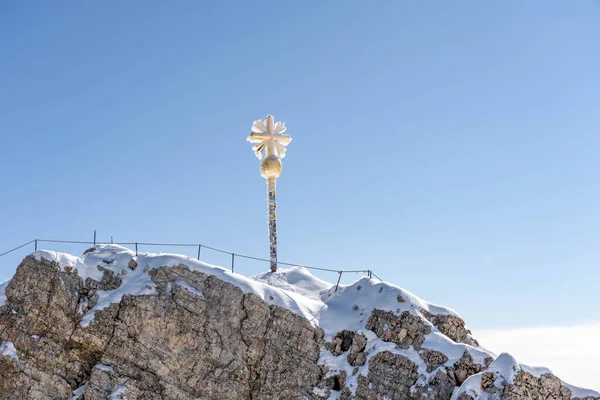 Zugspitze 'nin tepesindeki altın haç yaz sabahı karla kaplı.