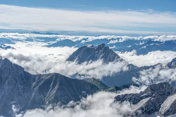 Ranní mlha mraků na vrcholu hory Zugspitze v létě v Německu — Stock fotografie