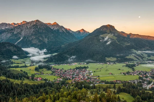 Luftaufnahme des deutschen Dorfes Bad Oberdorf bei Sonnenaufgang nahe Zugspitze und österreichischer Grenze — Stockfoto