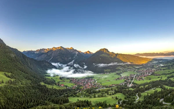 Luftaufnahme des deutschen Dorfes Bad Oberdorf bei Sonnenaufgang nahe Zugspitze und österreichischer Grenze — Stockfoto
