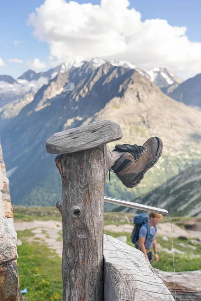 Olpererhutte, Rakousko - 7. srpna 2020: Ztracená obuv na vodovodním kohoutku před restaurací — Stock fotografie