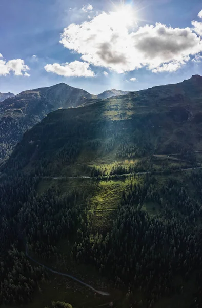 Aerial drone shot of sun light pearcing through clouds on high alpine road on Grossglockner mountain in Austria — Zdjęcie stockowe