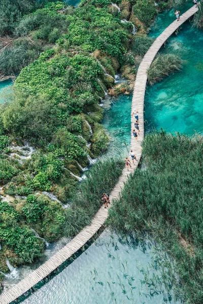 Plitvice, Croatie - 11 août 2020 : Les touristes traversent la région du lac sur un pont dans un parc national — Photo