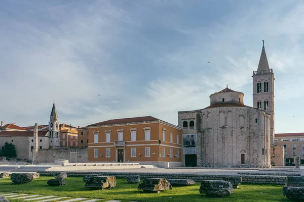 Задар, Хорватия - 13 августа 2020 г.: Римский реликтовый камень на старой городской площади с видом на церковь Святого Доната — стоковое фото