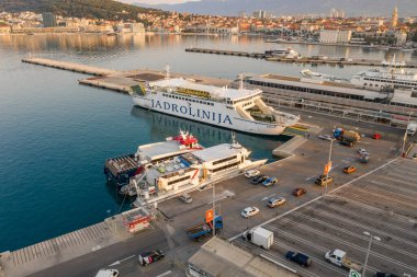 Split, Hırvatistan - 14 Ağustos 2020: Güneşin doğduğu saatte eski kasaba limanında feribot iskelesinin insansız hava aracı görüntüsü