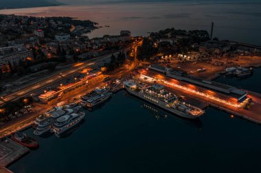 Split, Hırvatistan - 15 Ağustos 2020: Eski kentteki feribot limanının hava aracı görüntüsü alacakaranlıkta ışıklar açık