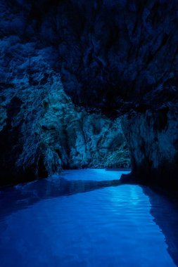 Bisevo, Hırvatistan - 16 Ağustos 2020: Komiza adası yakınlarındaki sakin mavi mağarada bir teknede turistler