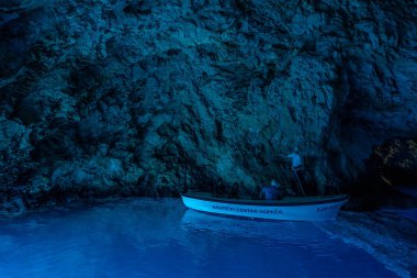 Bisevo, Hırvatistan - 16 Ağustos 2020: Komiza adası yakınlarındaki sakin mavi mağarada bir teknede turistler