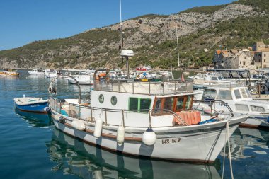 Komiza, Hırvatistan - 16 Ağustos 2020: Güneşli öğleden sonra eski kasaba liman manzarası