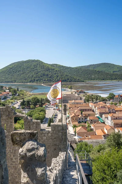 Ston, Chorwacja - 20 sierpnia 2020: Latem rano flaga Ragusa wisząca na ścianie Ston na wzgórzu — Zdjęcie stockowe