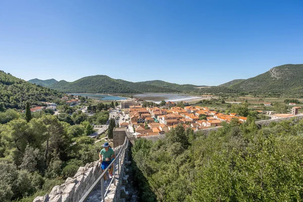 Ston, Chorwacja - 20 sierpnia 2020: spacer turystyczny po wąskiej kamiennej drodze po Murze Stona w letni poranek — Zdjęcie stockowe