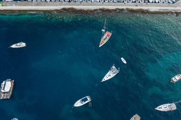 Aerial overhead drone shot of boats in Adriatic sea by Komiza town of Vis Island in Croatia before sunrise