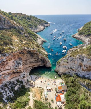 Turistlerin insansız hava aracı görüntüleri Hırvatistan 'ın Vis Adası' ndaki Adriyatik Denizi 'nin Stiniva koyunda güneş banyosu yapıyor.