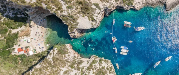 Aerial panoramic overhead drone shot of yachts at adriatic sea tourists at Stiniva beach on Vis Island in Croatia summer