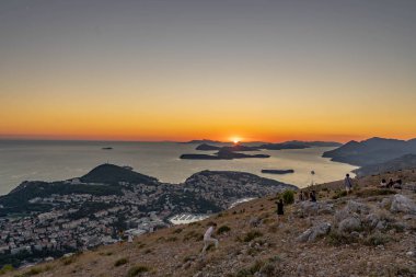 Dubrovnik, Hırvatistan - 23 Ağustos 2020: Turistler, eski Adriyatik Adaları kıyı şeridi Mountain Srd 'den günbatımına hayran