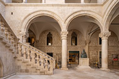 Dubrovnik, Hırvatistan - 22 Ağustos 2020: Eski kentteki Rektörler Sarayı 'nda bronz heykeli olan Atriyum merdivenleri