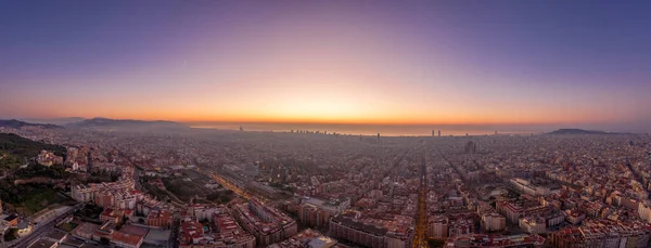 Aerial panorama drone shot of Barcelona with sunrise over sea horizon in Spain winter dawn