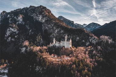 Almanya 'da kış güneşinde karlı tepedeki Neuschwanstein Şatosu' nun insansız hava aracı görüntüleri.