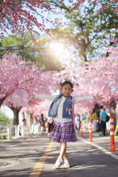 在樱花树下花园的亚洲小女孩 — 图库照片