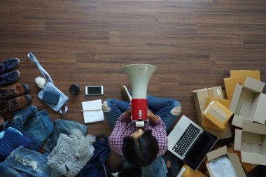  En tepedeki kadınlar ellerinde megafon reklamcılığı mesajları tutarak evden ahşap zemin üzerinde posta paketiyle pazarlama yapıyorlar. İnternetten küçük işletme sahipleri fikirleri satıyorlar.