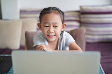 Asyalı küçük kız ev ödevi öğreniyor online ders, sosyal uzaklık online eğitim ev fikri konsepti