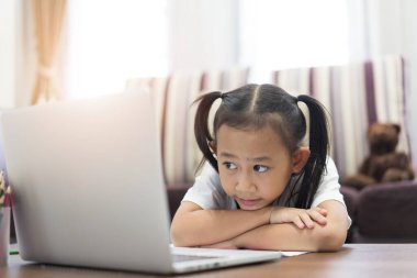 Asyalı küçük kız evde sanal internet öğreniyor.