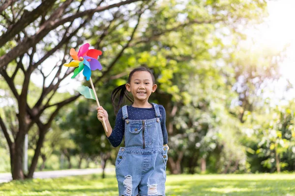 Szczęśliwy Azji Mała Dziewczynka Działa Park Zabawy Papier Wiatrak — Zdjęcie stockowe