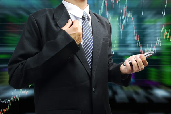 Business man holding mobile phone with stock market graph — Stock Photo, Image