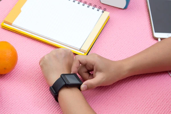 Close up tiro de uma mão mulher com smartwatch no tapete de exercício — Fotografia de Stock