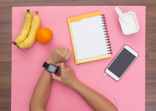 Woman hand with smartwatch on exercise mat — Stock Photo, Image