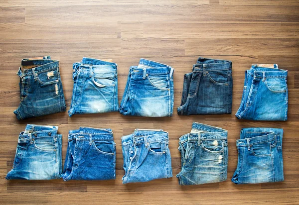 Collection jeans stacked on a wooden background