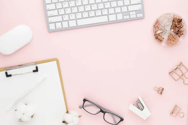 Office desk table top view with office supply, pink table with copy space, pink color workplace composition, flat lay