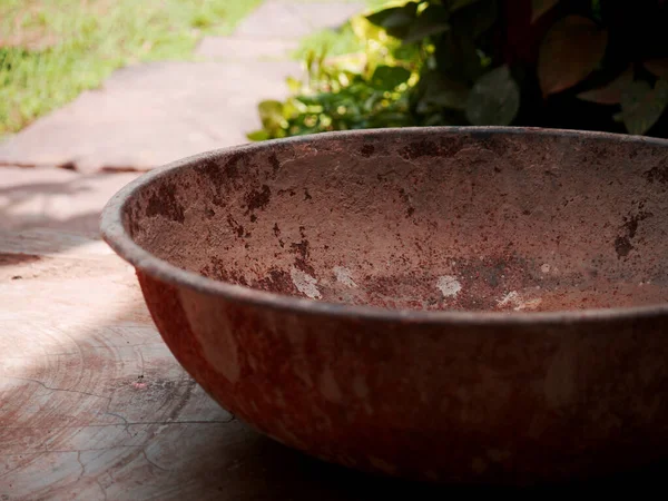 Bahçe arka planında çok eski bir demir tava var.